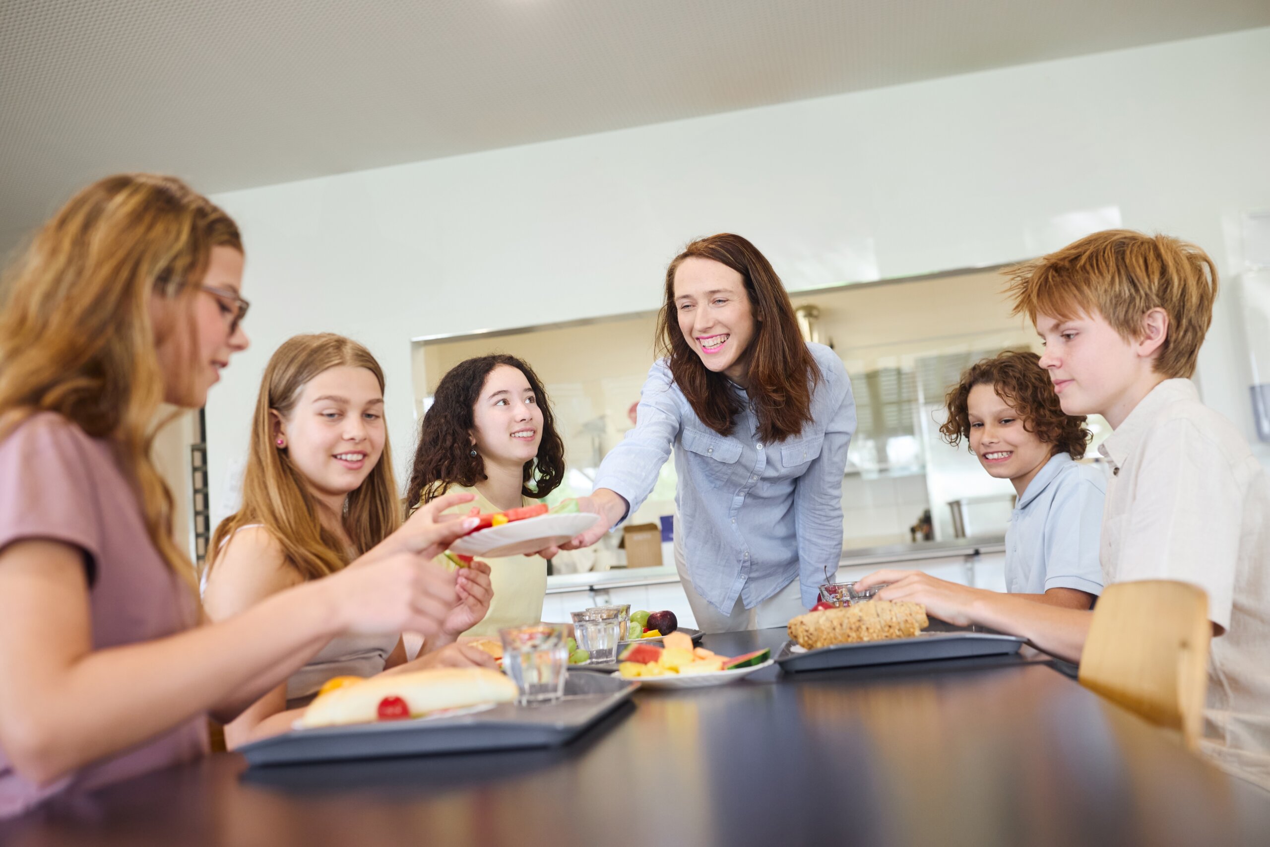 A,Group,Of,Students,Sits,In,A,School,Cafeteria,,Enjoying